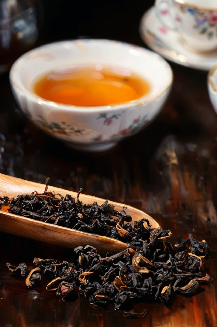 Black loose leaf tea in a wooden scoop